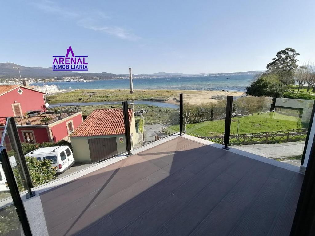 a balcony with a view of the ocean from a house at A Ponte in Pobra do Caramiñal