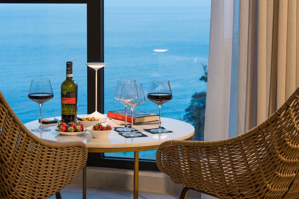 una mesa con copas de vino y un plato de comida en Belduomo, en Taormina
