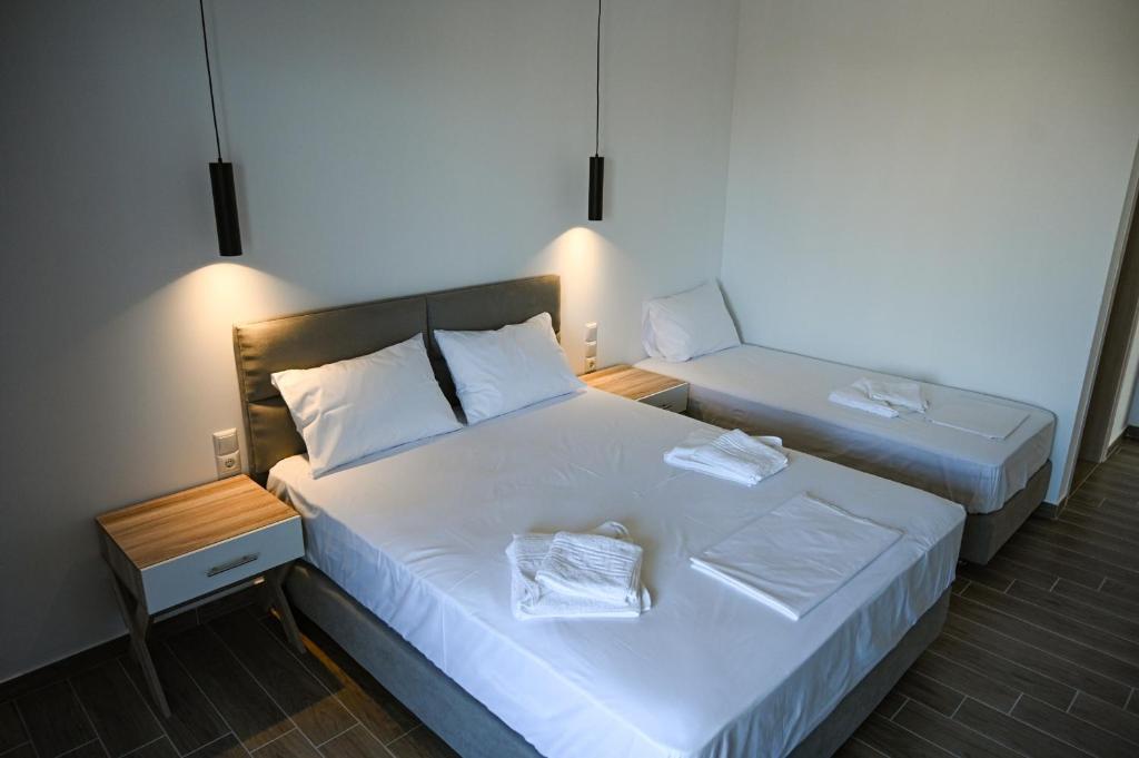 a bedroom with two beds with white sheets at Costa Varda Apartments in Mourteri