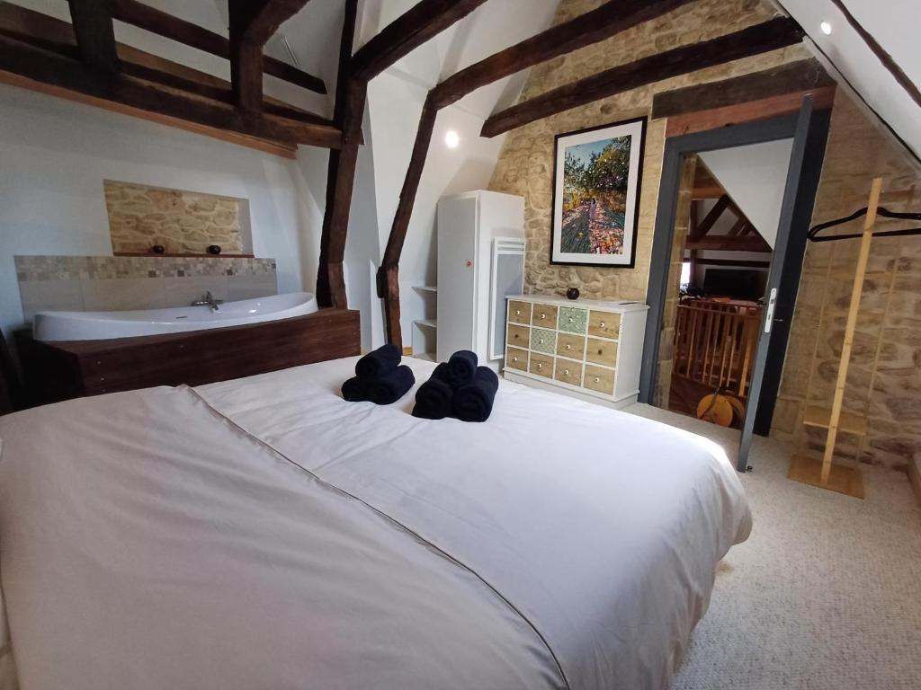 - une chambre avec un grand lit blanc et une baignoire dans l'établissement La cabane suspendue de Sarlat, à Sarlat-la-Canéda