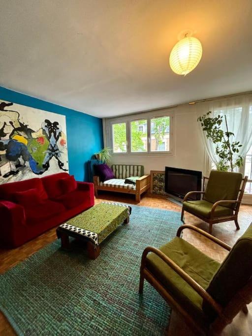 - un salon avec un canapé et des fauteuils rouges dans l'établissement Grand appartement familial, proche Stade de France, à Aubervilliers