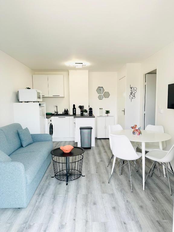 un salon avec un canapé bleu et une table dans l'établissement Appartement T2 4 personnes RDC 50m plage et corniche, à Saint-Hilaire-de-Riez