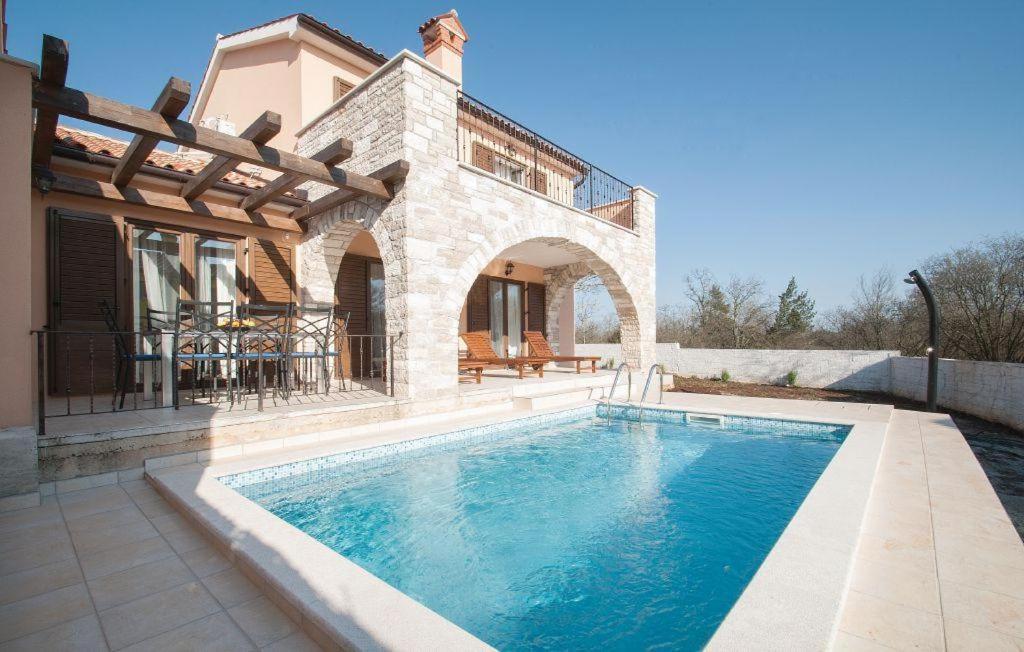 a swimming pool in front of a house at Villa With Pool in Croatia Vrsar in Gradina