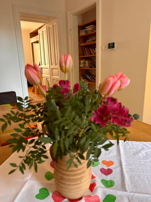 a vase filled with pink flowers on a table at Urban Apartment for Erasmus Student, Zentrum in Graz