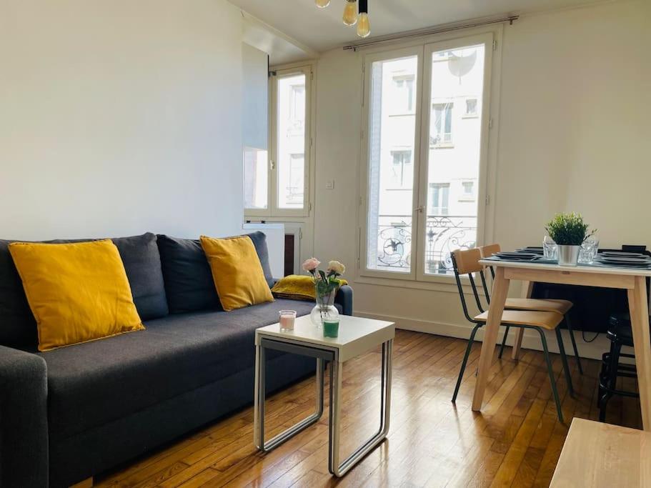 a living room with a couch and a table at Charming & cocooning flat - Canal de l’Ourq in Pantin