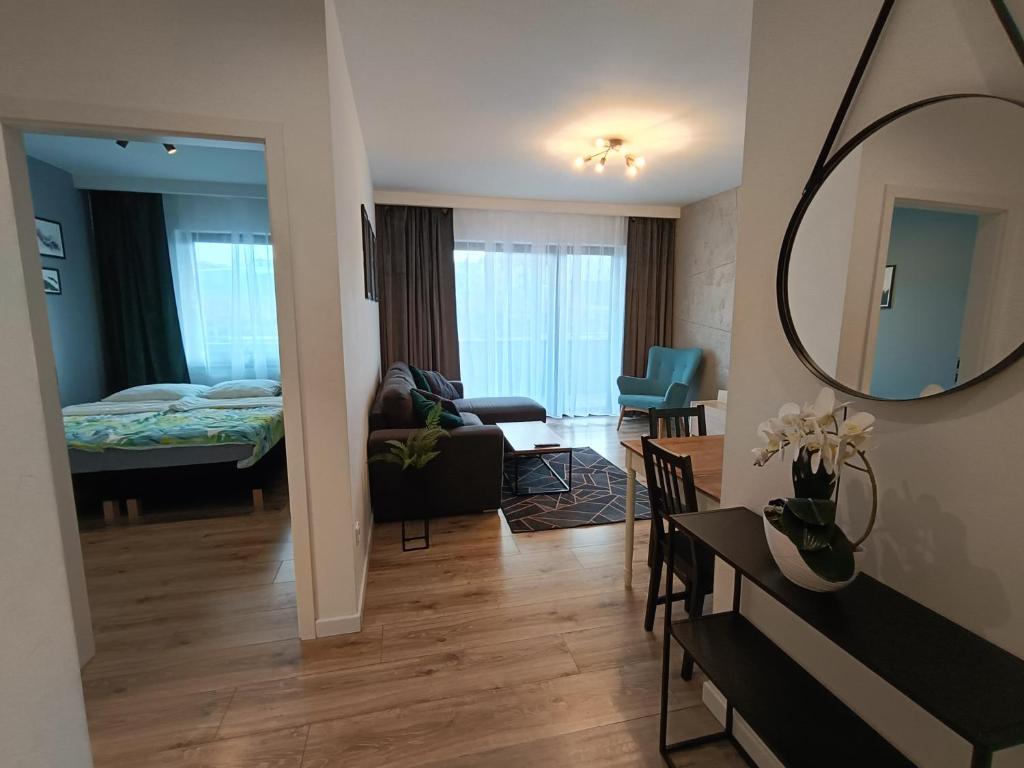 a living room and a bedroom with a bed and a mirror at Apartament Siedlce in Siedlce