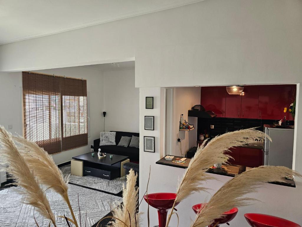 uma sala de estar com cadeiras vermelhas e um sofá em Seaty Apartment em Corinto