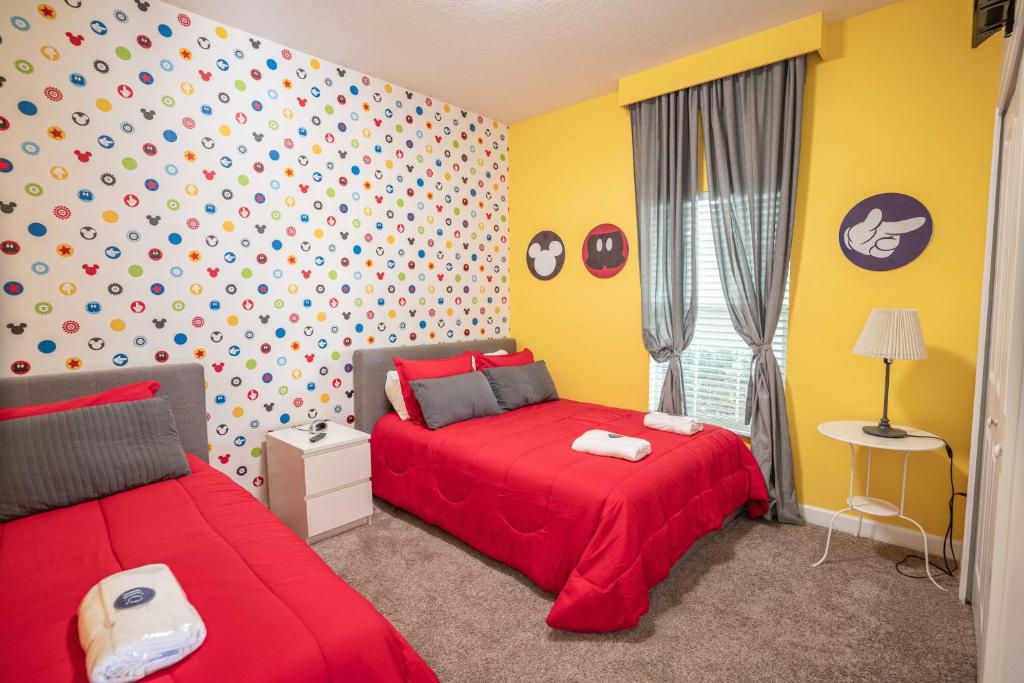 una camera con due letti con lenzuola rosse e pareti gialle di ST3064 Fabulosa casa perto da Disney a Kissimmee