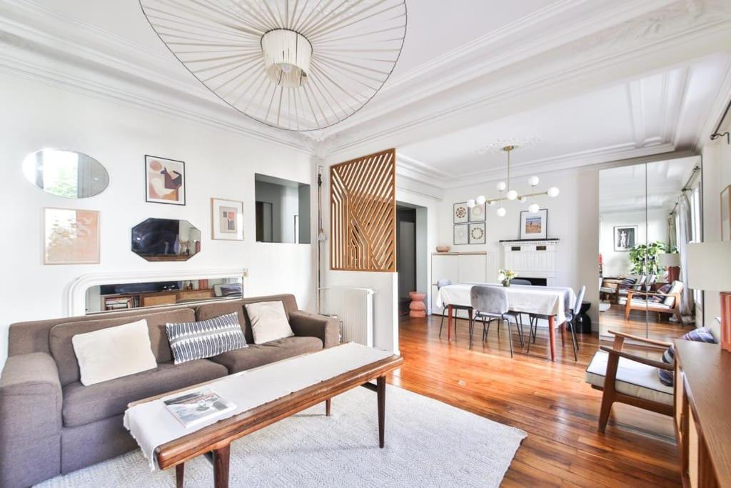 un salon avec un canapé et une table dans l'établissement Appartement chaleureux au cœur de Montmartre, à Paris