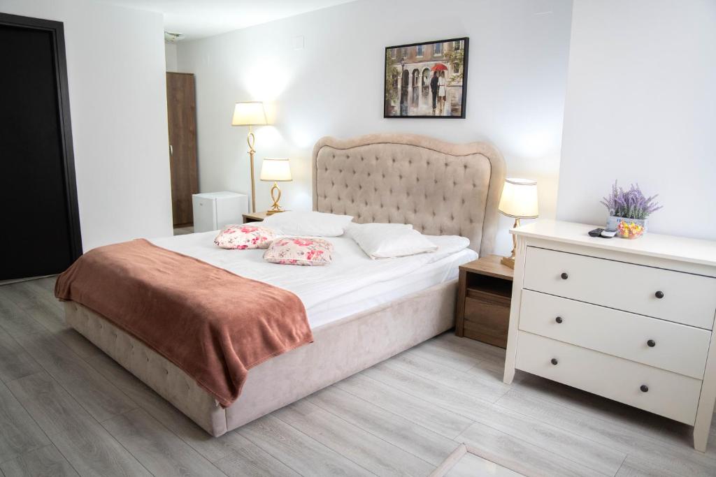 a bedroom with a large bed and a dresser at Casa Alis in Oradea