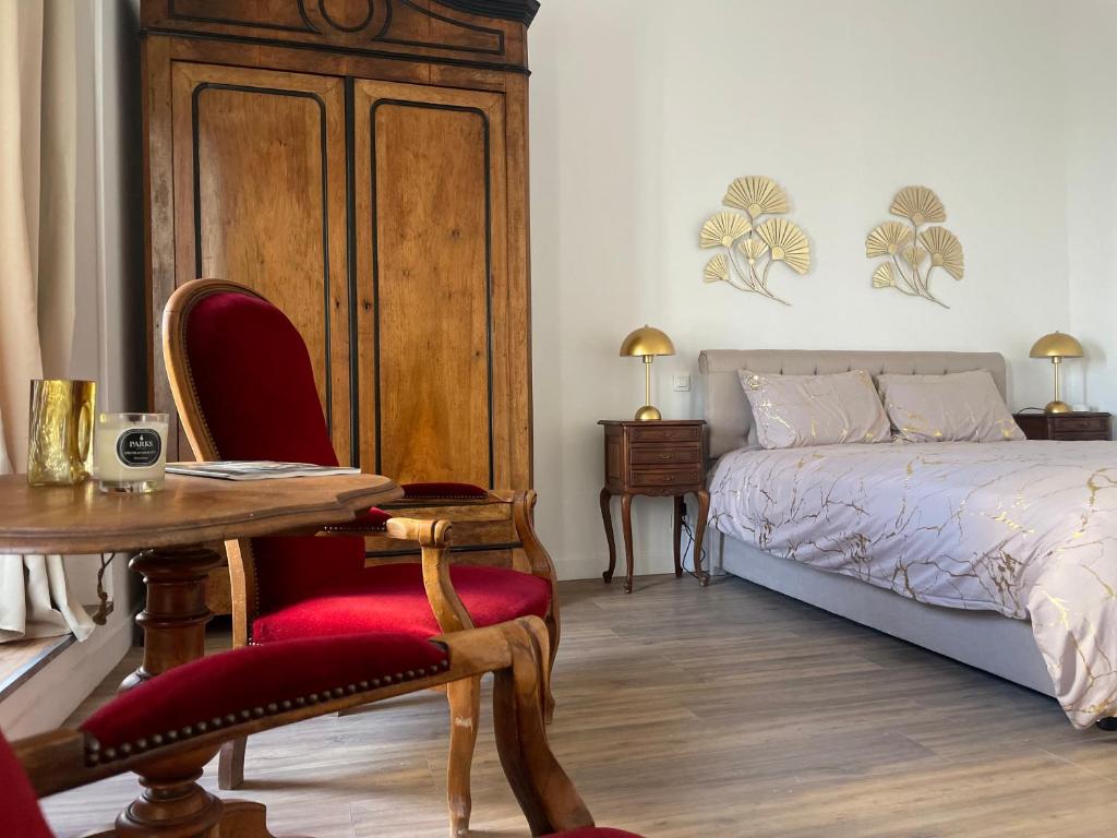 une chambre avec un lit, une table et des chaises dans l'établissement Luxe et élégance en face des Halles, à Béziers