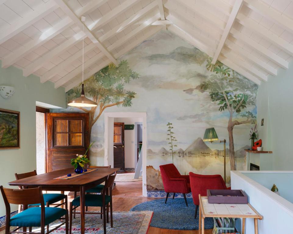 a dining room with a painting on the wall at Casa da Encosta - Hillside cabin near the sea in Colares