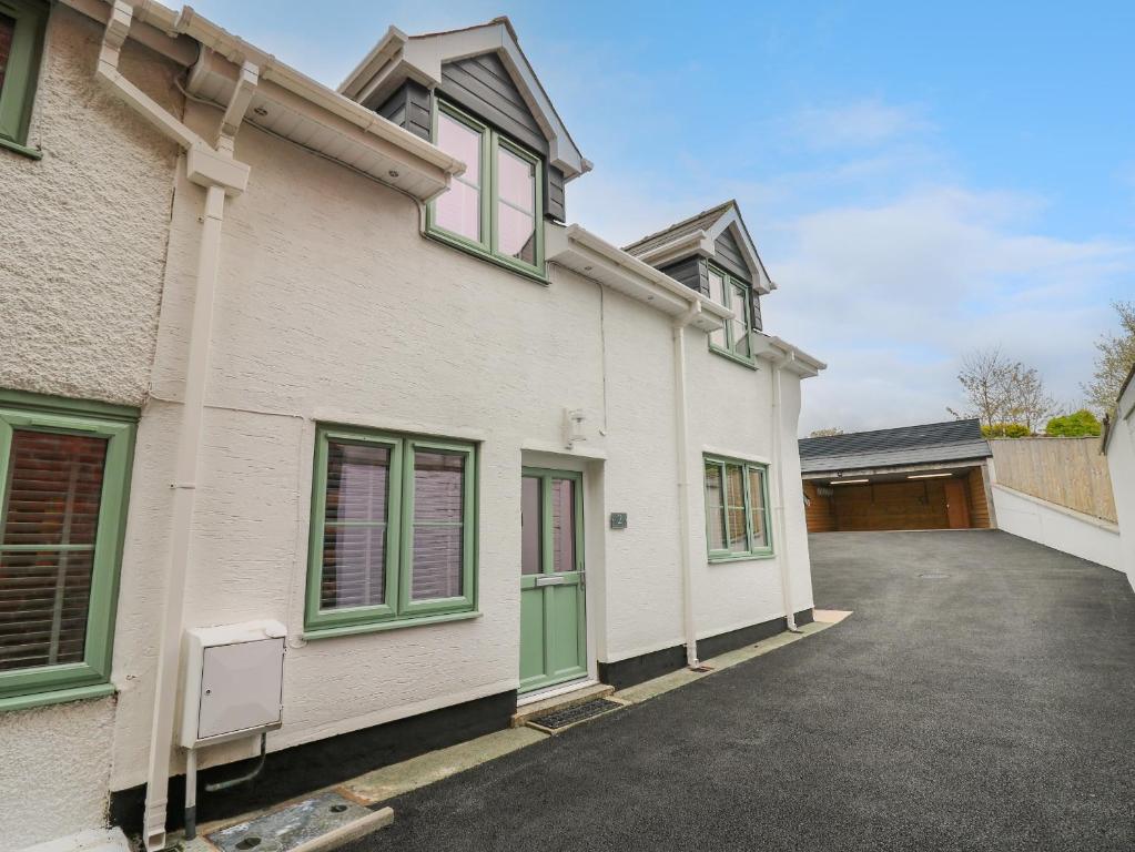 a white house with green windows and a driveway at 2 Penporth in Rhayader