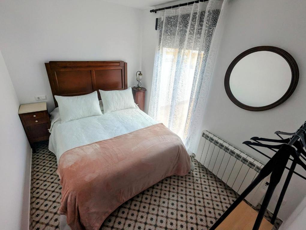 a bedroom with a large bed and a mirror at Alojamiento 13 Jotas in Iniesta