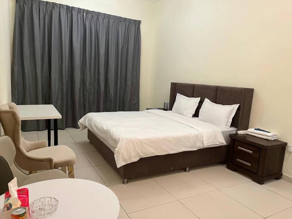 een slaapkamer met een bed, een tafel en een stoel bij Wehome Dubai International City in Dubai