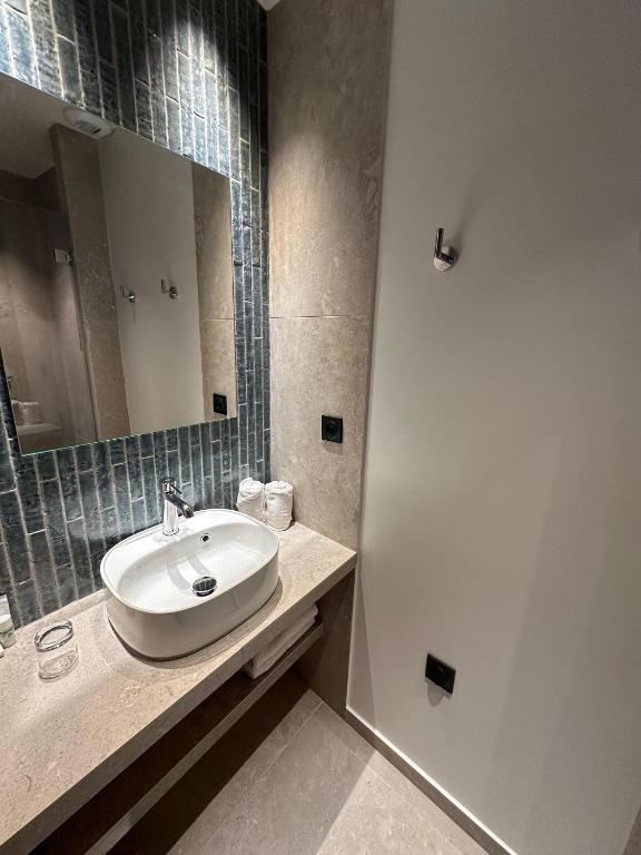 a bathroom with a sink and a mirror at Hôtel Le Médiéval Palais des Papes in Avignon