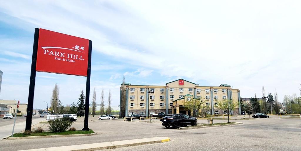 un estacionamiento con una señal roja delante de un edificio en Park Hill Inn & Suite, en Red Deer
