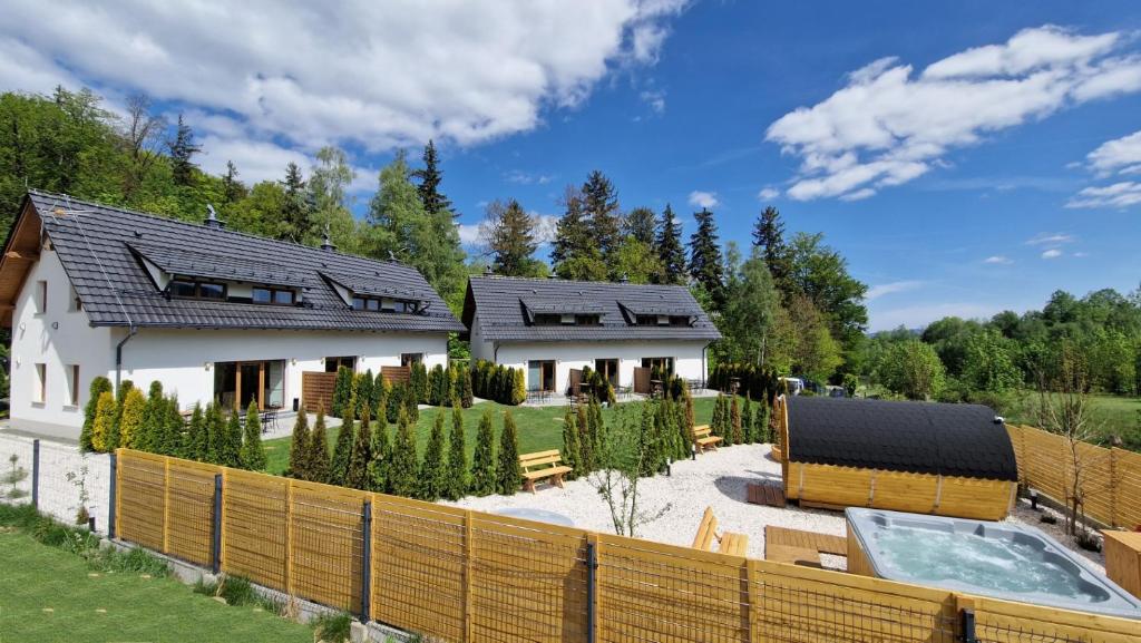 a house with a swimming pool and a fence at Widokowo - Domki z widokiem na Śnieżkę in Karpacz