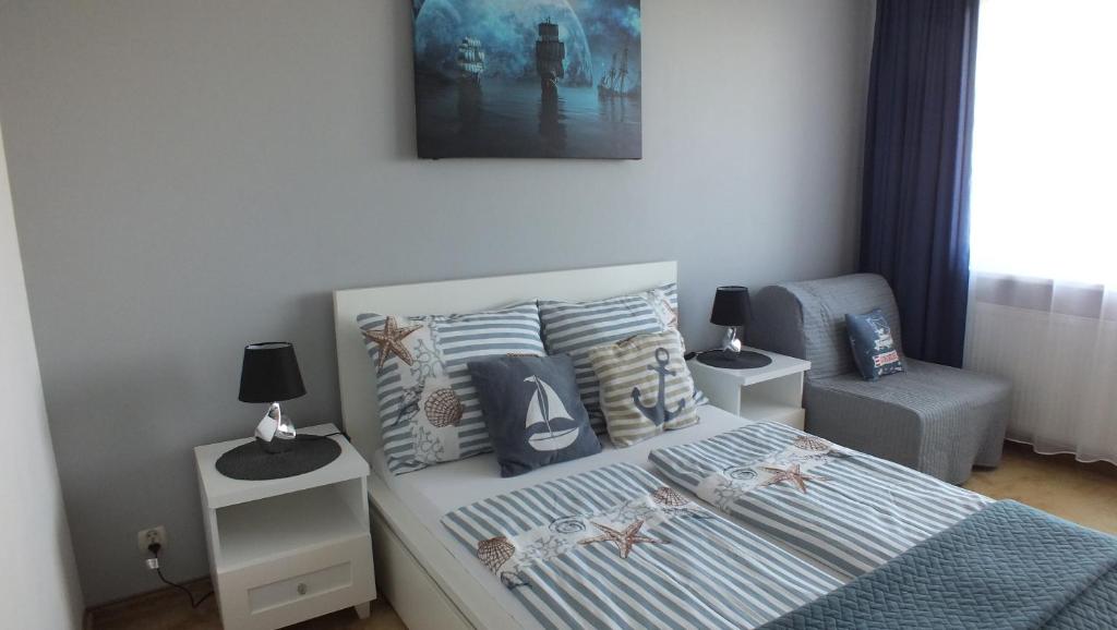 sypialnia z łóżkiem z poduszkami i zdjęciem w obiekcie Apartament Nad Parsętą w Kołobrzegu