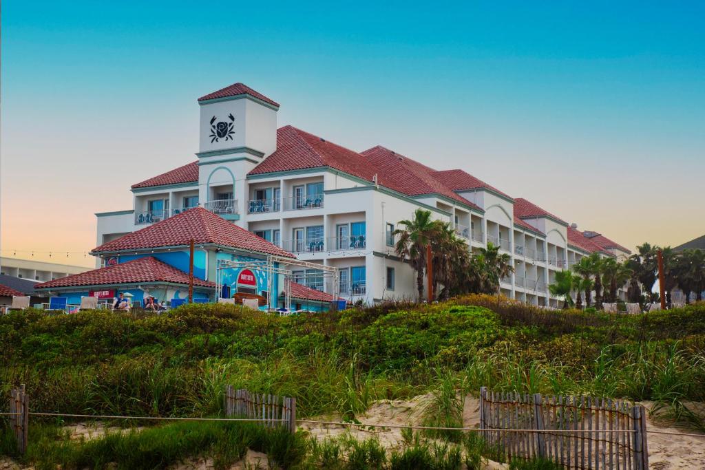 un grand bâtiment avec une tour d'horloge sur une plage dans l'établissement Sand Rose Beach Resort, à South Padre Island