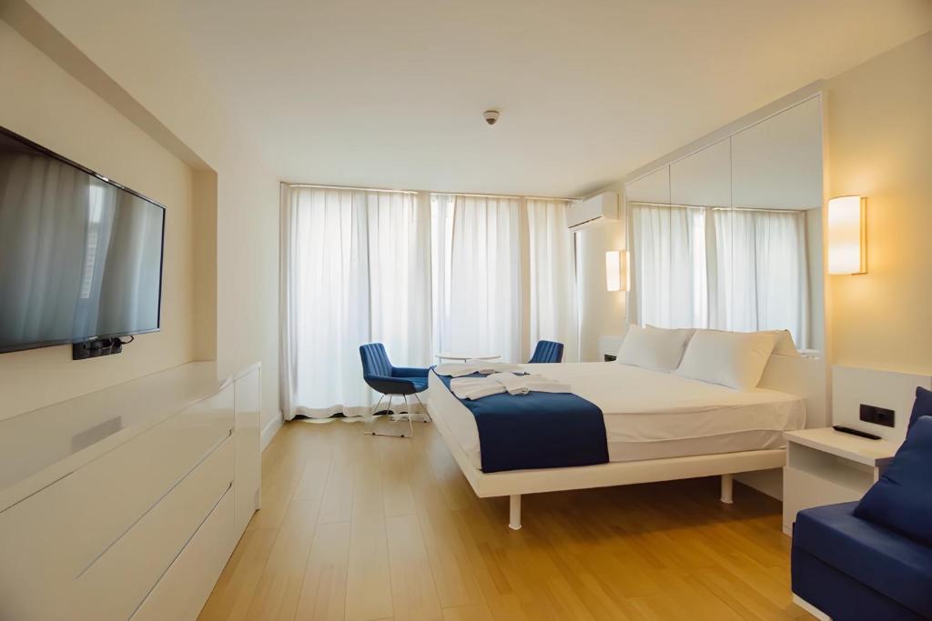 ein Hotelzimmer mit einem Bett und einem Flachbild-TV in der Unterkunft Hotel in Orbi City Official in Batumi