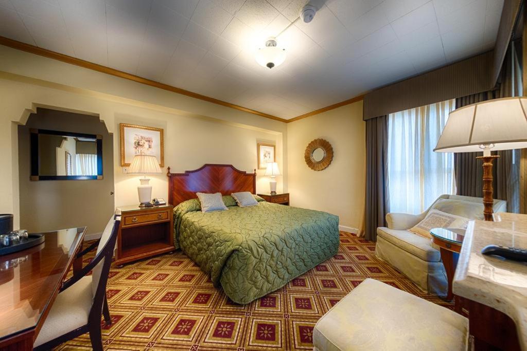 サンフランシスコにあるEMBASSY HOTELのベッドとデスクが備わるホテルルームです。