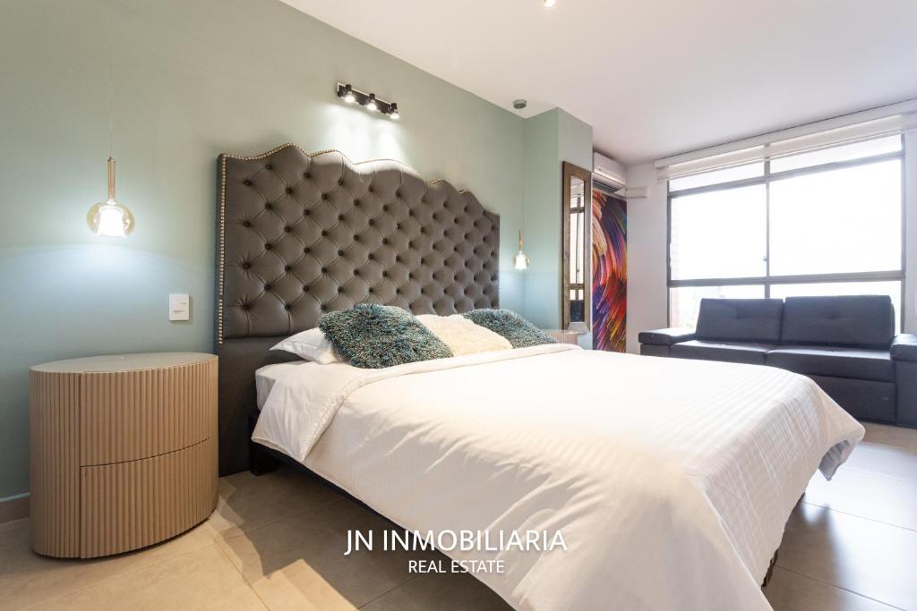 a bedroom with a large bed and a chair at Park 42 APARTASUITES in Medellín