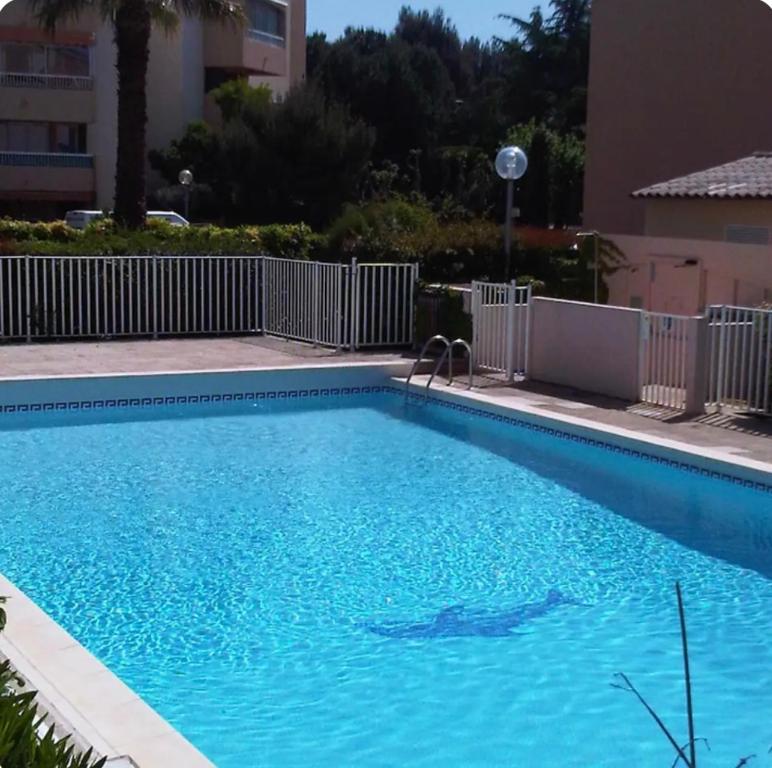 une grande piscine bleue dans un immeuble dans l'établissement Appartement Sanary Sur Mer., à Sanary-sur-Mer
