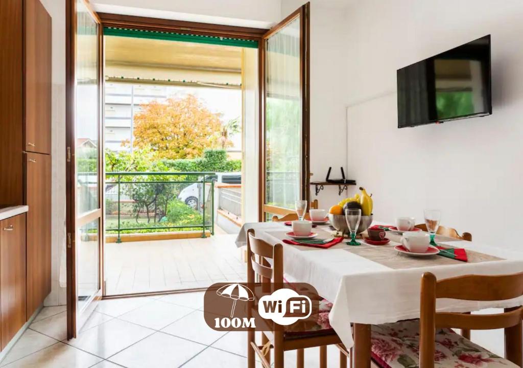 una sala da pranzo con tavolo e balcone di HoliHome_Colombo - Open Space, 100m dal mare! a Tortoreto