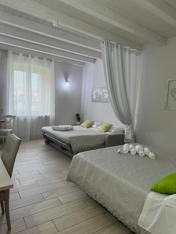 a bedroom with two beds and a table and chairs at B&B La Terrazza in Pozzolengo