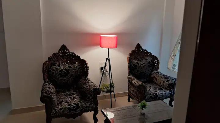 2 sedie e una lampada in soggiorno di Halcyon - Tropical Elegance - 2BHK a Moira