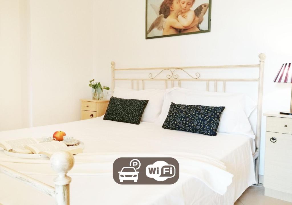 a bedroom with a white bed with a white bedspread at HoliHome_Parri in Tortoreto Lido