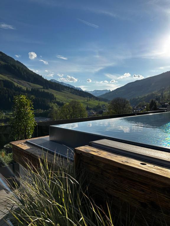 una piscina con vista sulle montagne di Appartements Casa Nuova a Saalbach Hinterglemm