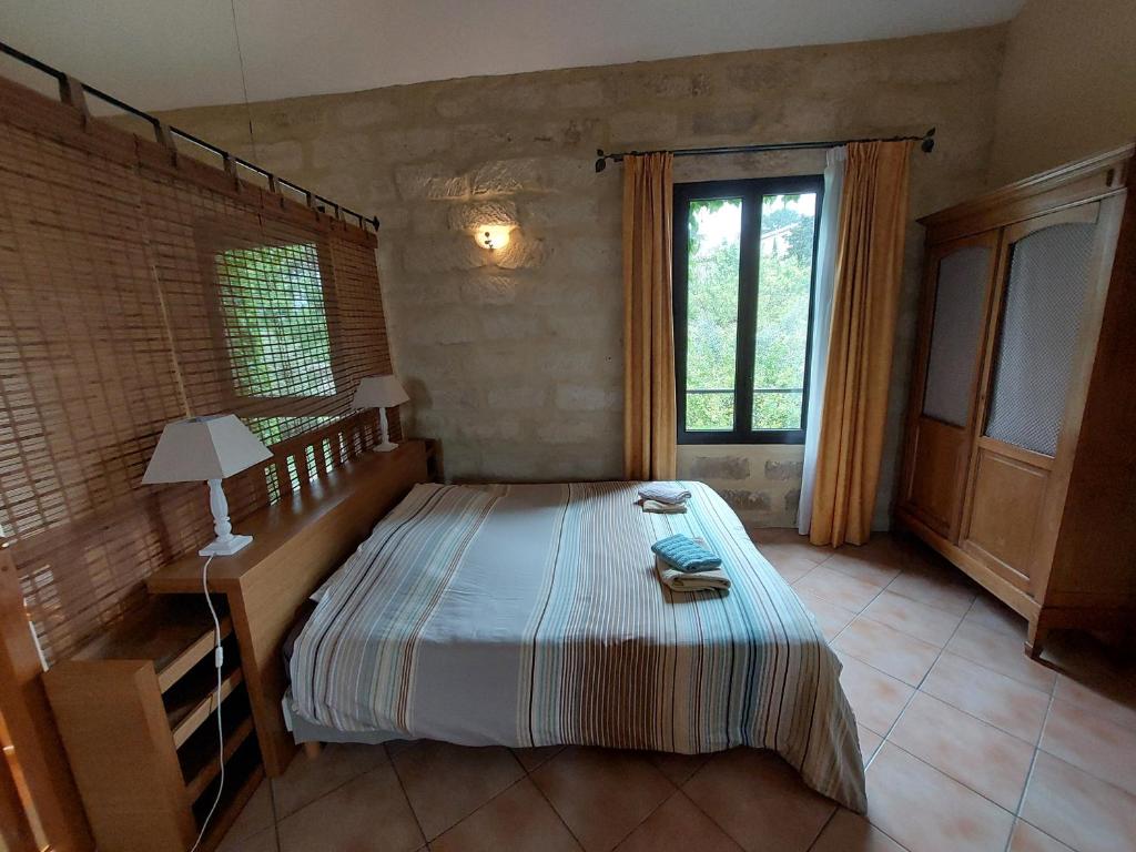 a bedroom with a bed and a window at Mas Fontclaire - Sommières in Sommières