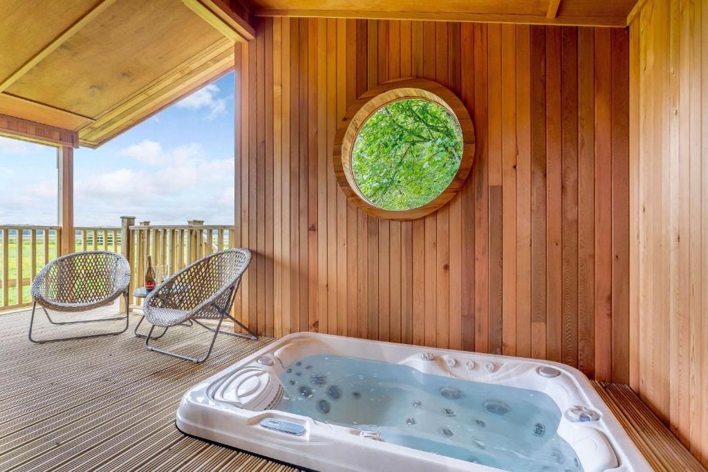 a jacuzzi tub on the deck of a house at Duet Lodge in Kingham