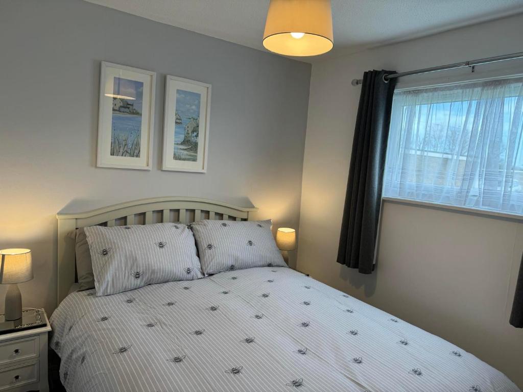a bedroom with a white bed and a window at 21 M&T Chalets ,2 bed chalet Florida holiday park , Hemsby in Hemsby