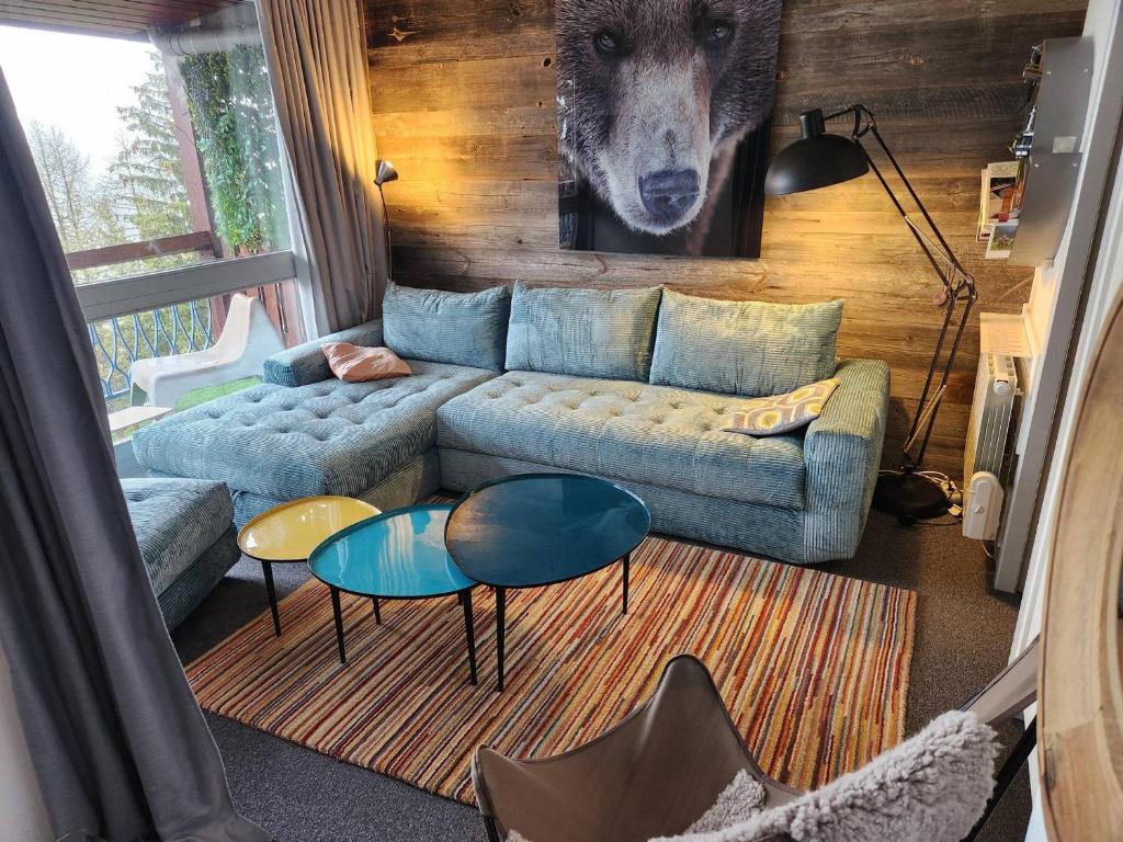 a living room with a blue couch and two tables at Appartement Les Arcs 1800, 3 pièces, 8 personnes - FR-1-346-305 in Arc 1800