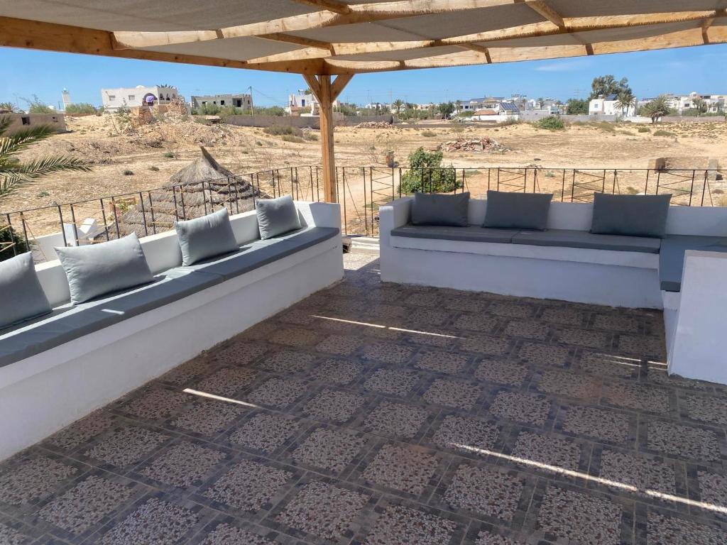 a couch sitting under a pavilion on a beach at Dar Zina in Al Maqārisah