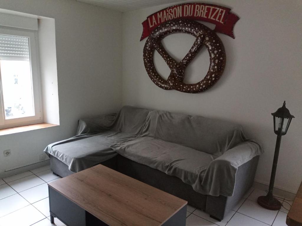 un salon avec un canapé et un signe de paix sur le mur dans l'établissement Maison de campagne, à Thiaucourt