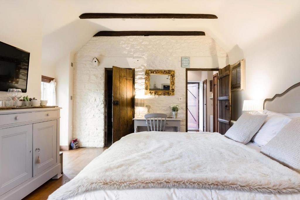 Romantic Little House near Bath في Rode: غرفة نوم بسرير ابيض كبير وطاولة