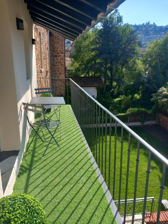 einen Balkon mit einem Tisch und Blick auf einen Hof in der Unterkunft le domaine de thizy in Thizy-les-Bourgs