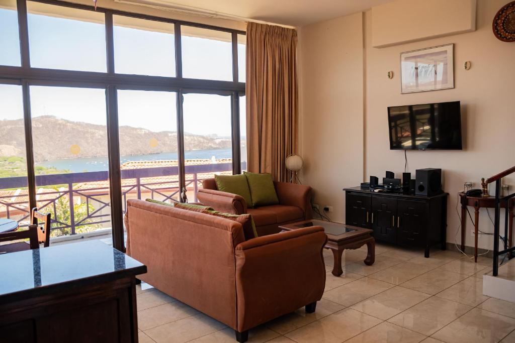 a living room with two chairs and a large window at VistaMar - La Morada del Ocaso in Playa Hermosa