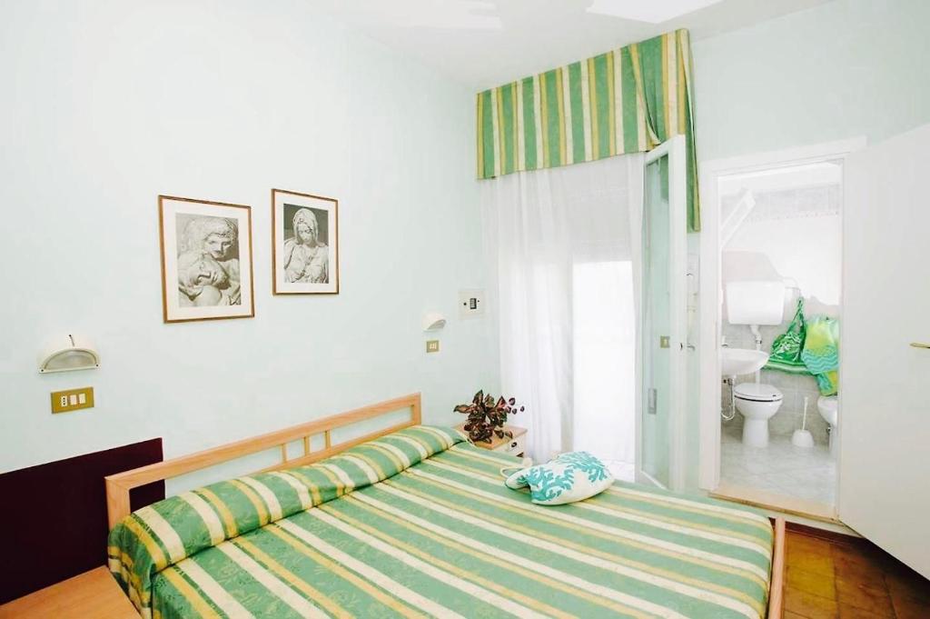 a bedroom with a bed and a bathroom with a window at King Relax Hotel in Cesenatico