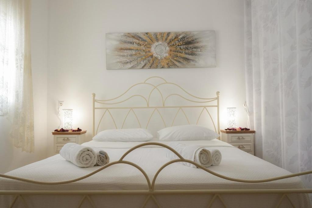 ein weißes Schlafzimmer mit einem Bett mit Handtüchern darauf in der Unterkunft Avlemonas Guest House in Avlemonas