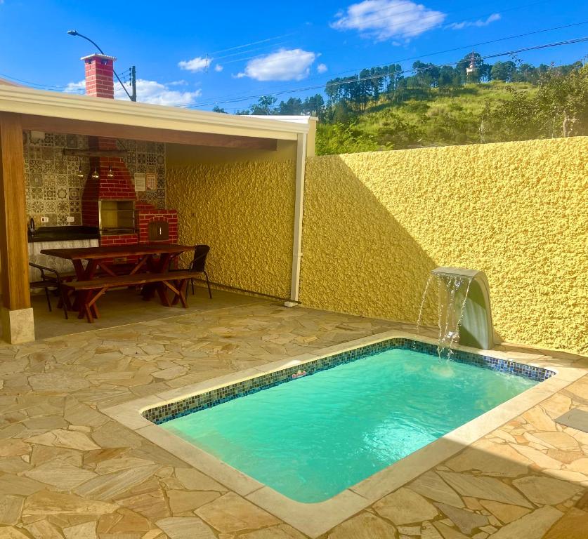 a swimming pool with a fountain in a backyard at Casa Piscina Centro Serra Negra 500m Fontana Trevi in Serra Negra