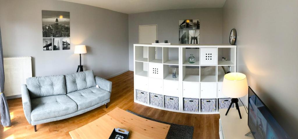 un salon avec un canapé et une chaise dans l'établissement Appartement 35m² terrasse sud, à Caen