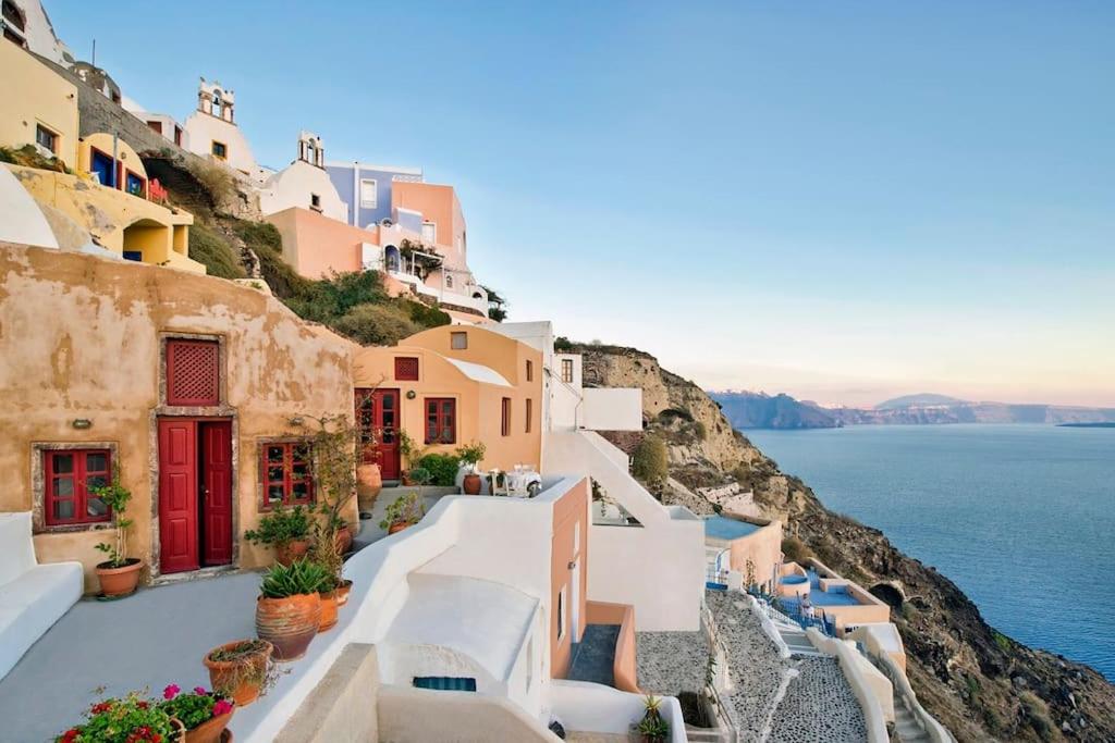 a group of buildings on a cliff next to the ocean at PORI HOUSE-VOLCANO VIEW in Oia