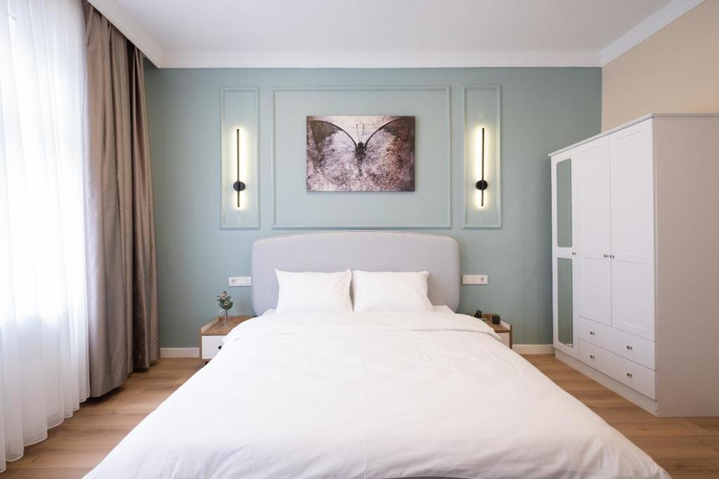 1 dormitorio con 1 cama blanca grande y paredes azules en Green sophia suite, en Estambul