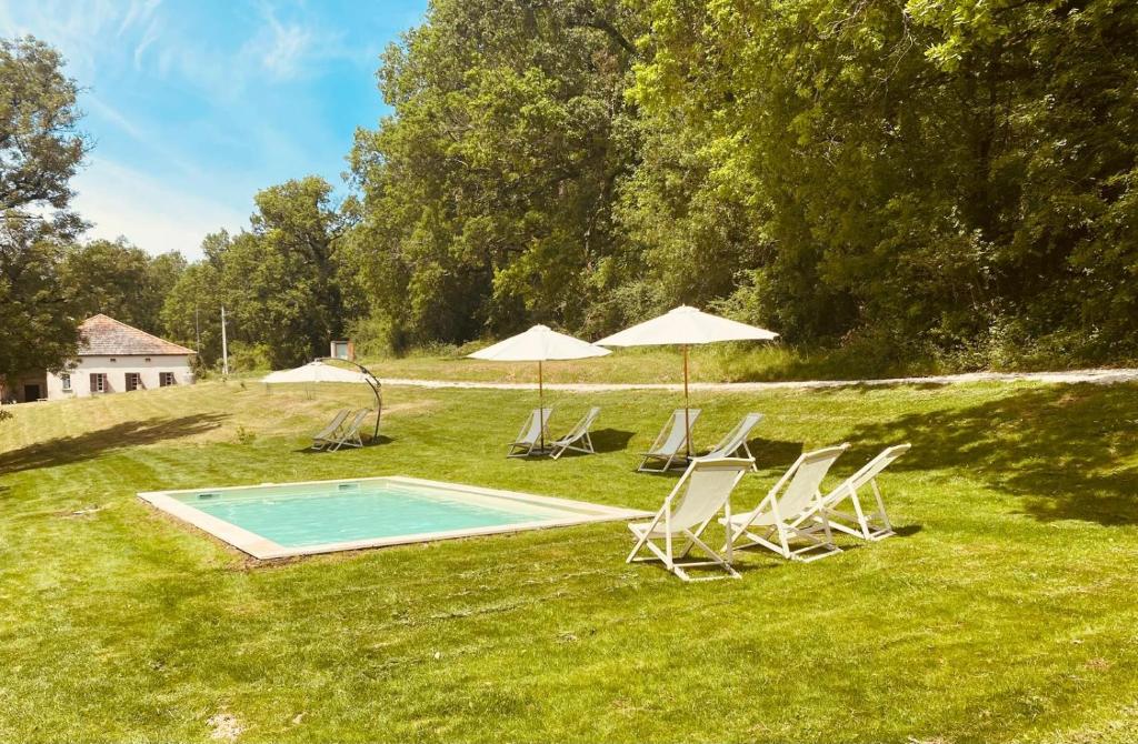 - un groupe de chaises longues et de parasols à côté de la piscine dans l'établissement Gîte de Fompesquiere, à Frespech
