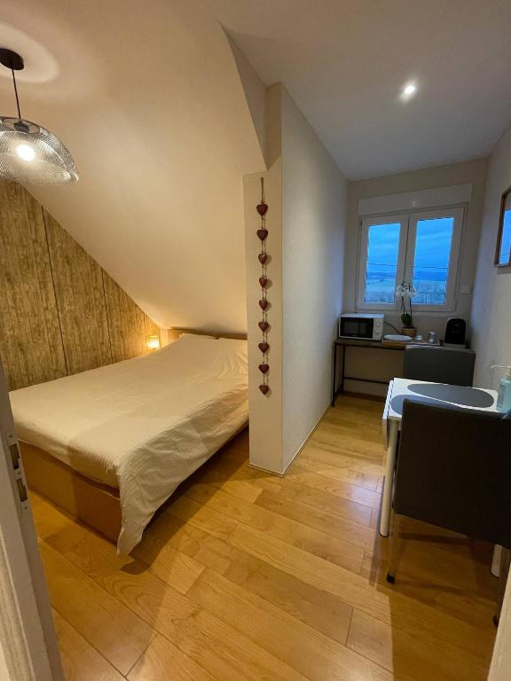 une chambre avec un lit et une table dans une pièce dans l'établissement Chambre proche de la citadelle, à Montmédy